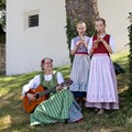 Eine Frau und zwei Mädchen im Werktagsgwand beim Musizieren