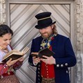 Eine Frau und ein Mann in Biedermeiertracht beim Lesen