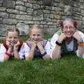 Zwei Mädchen und eine Frau liegen im Gras und schauen in die Kamera. Zwei Mädchen und eine Frau liegen im Gras und schauen in die Kamera.