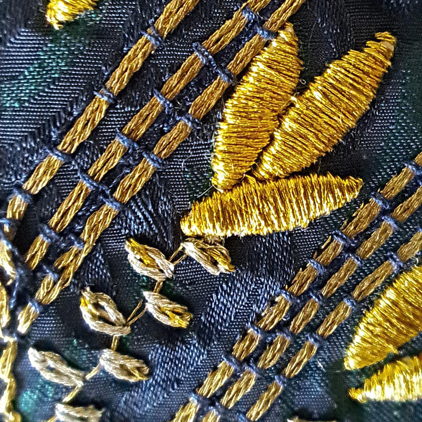 Goldstickerei auf blauem Stoff